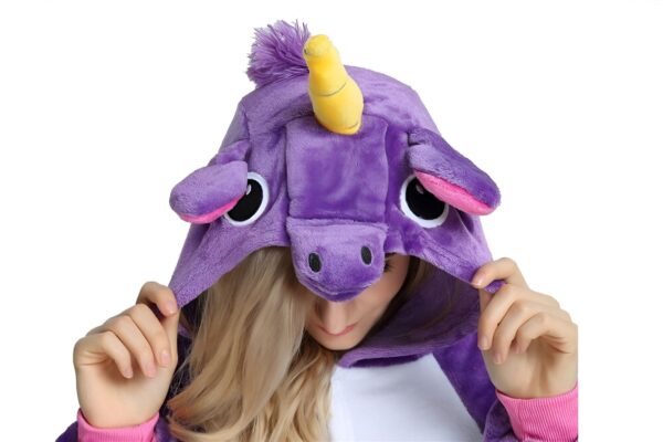 combinaison-licorne-femme-violette-5a.jpg Une femme porte une combinaison pyjama licorne violette avec une capuche. La capuche a une corne jaune, des oreilles roses et des yeux noirs. La combinaison est ouverte sur le devant et l'on peut voir que la femme porte un haut rose en dessous.