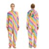 Une femme porte une combinaison pyjama licorne arc-en-ciel avec une capuche et une queue de cheval. La combinaison est rose, jaune, verte, bleue et violette avec des étoiles blanches. La femme est debout, dos à la caméra.