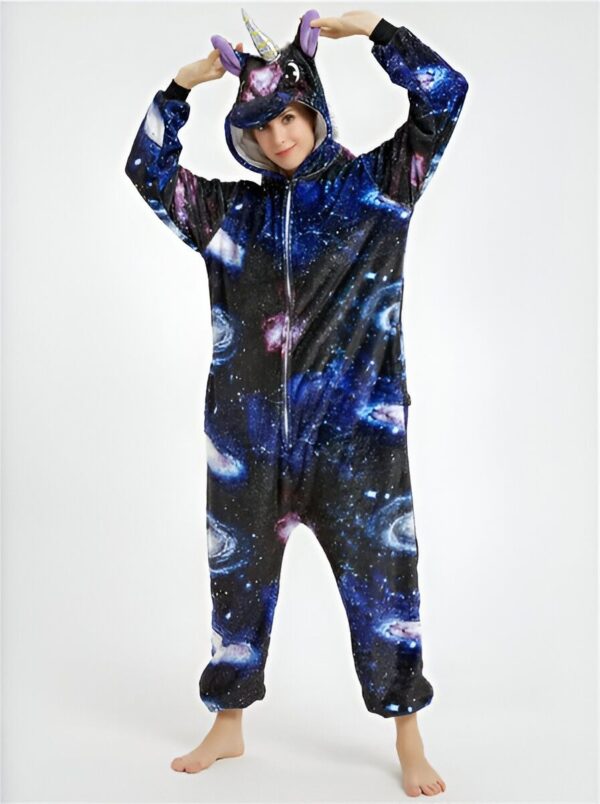 Une femme portant une combinaison pyjama intégrale en forme de licorne avec un motif de galaxie colorée. Elle sourit et pose avec ses mains au-dessus de sa tête., 45501990043903,45501990076671,45501990109439,45501990142207,45501990174975,45501990207743,45501990240511,45501990273279 | Licorne Shop