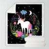 Couverture noire avec motif de licorne blanche, crinière multicolore, entourée de fleurs, d'étoiles, d'une lune et d'un nuage. Deux couvertures blanches sont pliées en bas., 45501034299647 | Licorne Shop