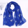 echarpe-bleue-licorne-a-corne-et-pompons-pour-femme-1a.jpg Écharpe bleu roi à motifs de chevaux argentés, posée à plat près d'un chapeau, de lunettes et d'un magazine. Accessoire de mode élégant et tendance pour femme., 45502083825919 | Licorne Shop