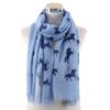 echarpe-chaude-et-douce-licorne-bleu-fonce-1a.jpg Écharpe bleu clair avec motifs d'unicorne marine sur un mannequin. Texture légère et franges délicates. Accessoire de mode original et tendance., 45502079828223 | Licorne Shop