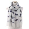 echarpe-licorne-brodee-en-laine-douce-1a.jpg Écharpe blanche avec des motifs de licornes bleues. L'écharpe est drapée sur un mannequin blanc, mettant en valeur son design élégant., 45502079631615 | Licorne Shop