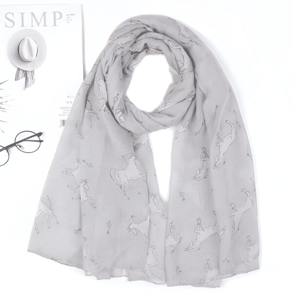 Écharpe gris clair avec motifs de cavaliers et de chevaux. Sur le côté, on aperçoit un magazine, un chapeau blanc et des lunettes rondes., 45502081433855 | Licorne Shop