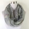 echarpe-tour-de-cou-licorne-grise-chaude-1a.jpg Écharpe tube gris clair à motifs de licornes stylisées, présentée sur un mannequin blanc. Accessoire de mode tendance., 45502092017919 | Licorne Shop