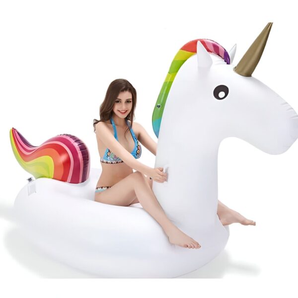 Une femme en maillot de bain assise sur une bouée gonflable licorne blanche avec des détails arc-en-ciel, idéale pour la piscine ou la plage. Amusez-vous avec ce jouet d'eau., 45501228155135 | Licorne Shop