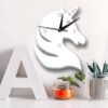 Gros plan sur une horloge murale en forme de tête de licorne blanche, entourée d'une lettre A blanche, d'une petite plante en pot et d'un pot à crayons rayé. Décoration intérieure ludique et moderne., 45501134930175 | Licorne Shop