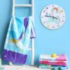 Image d'une chambre d'enfant avec une échelle blanche, une serviette de plage colorée, une horloge murale licorne et une pile de serviettes. Décoration douce et ludique pour une ambiance joyeuse et enfantine., 45501135552767 | Licorne Shop