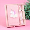 Boîte cadeau rose avec un carnet décoré d'une licorne blanche et rose avec un nuage duveteux blanc, ainsi qu'un stylo rose surmonté d'une tête de licorne, présenté sur un fond rose clair., 45501155442943 | Licorne Shop