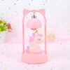 lampe-de-chevet-licorne-rose-2a.jpg Une veilleuse rose en forme de licorne avec des ailes et une crinière dorée. La licorne est allongée sur un nuage et est entourée d'étoiles.