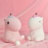 Deux veilleuses en forme de licorne, une rose et une blanche, toutes les deux avec une corne et une crinière colorées.