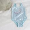 Maillot de bain bleu scintillant pour enfant avec motif licorne pailletée, présenté à côté d'un chapeau de paille sur un tissu blanc. Vêtement de plage d'été pour filles., 45501116547327 | Licorne Shop