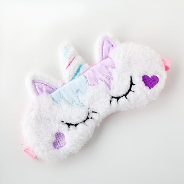Masque de sommeil en forme de licorne blanche en peluche avec des détails colorés (corne, crinière, oreilles) et des cœurs violets. Bande élastique rose., 45501057073407 | Licorne Shop