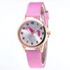 montre-licorne-cuir-rose-1a.jpg Une montre rose avec un cadran rond et un bracelet en cuir rose. Sur le cadran, il y a une image d'une licorne blanche et rose.
