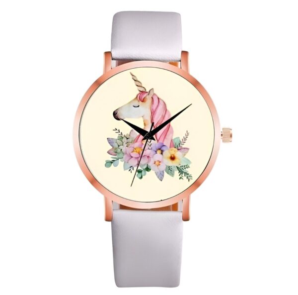 Une montre blanche avec un cadran rond et un bracelet en cuir blanc. Le cadran représente une licorne blanche avec une crinière et une queue roses. La licorne est entourée de fleurs roses, jaunes et bleues.