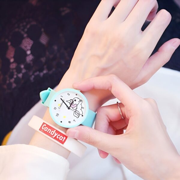 montre-licorne-kawaii-bleu-1a.jpg Une personne porte une montre Candycat bleue avec un cadran blanc et un bracelet en silicone. Le cadran de la montre est décoré d'un motif de licorne.
