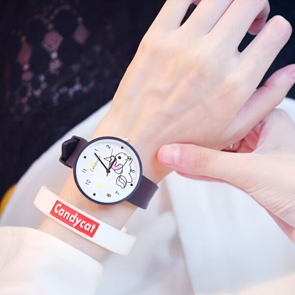 montre-licorne-kawaii-noir-1a.jpg Une jeune fille porte une montre blanche avec un lapin imprimé sur le cadran. Le bracelet de la montre est noir.