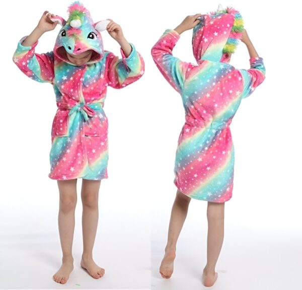peignoir-licorne-ado-fille-1a-1.jpg Une jeune fille porte une robe de chambre licorne rose et arc-en-ciel avec une capuche. La robe de chambre est à manches longues et a une ceinture à la taille. La capuche est doublée de polaire rose. La jeune fille est pieds nus et a les cheveux longs et blonds. Elle sourit et regarde l'appareil photo.