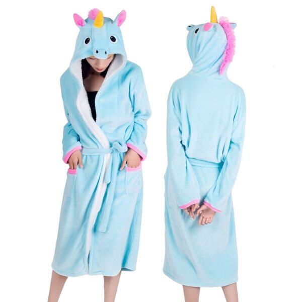 peignoir-licorne-adulte-bleu-1a.jpg Une femme porte une robe de chambre licorne bleue avec une capuche. La robe de chambre est ouverte, on peut voir qu'elle est doublée de polaire blanche. La capuche est également doublée de polaire blanche et possède des oreilles et une corne de licorne. La femme est vue de dos et de face.