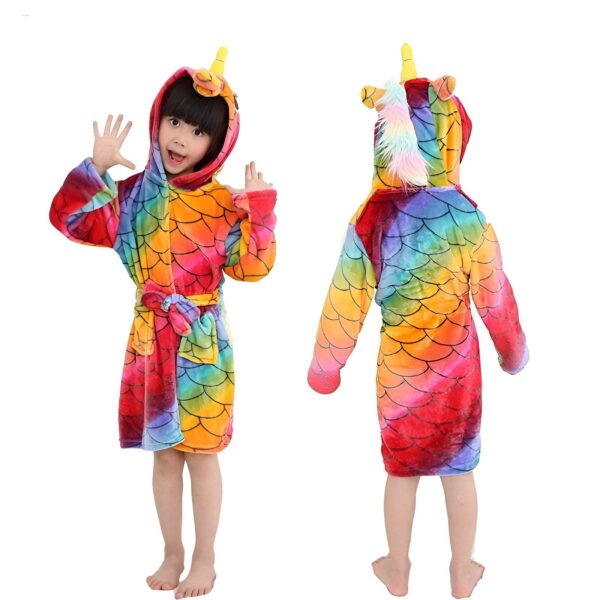 peignoir-licorne-enfant-original-1a.jpg Une jeune fille porte une robe de chambre à capuche en forme de licorne. La robe de chambre est arc-en-ciel et a une ceinture. La capuche est dotée d'une corne de licorne et d'oreilles.
