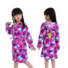 peignoir-licorne-enfant-violet-a-capuche-1a.jpg Une jeune fille porte une robe de chambre licorne violette et rose. La robe de chambre a une capuche avec une tête de licorne en 3D. La robe de chambre est également dotée d'une ceinture.