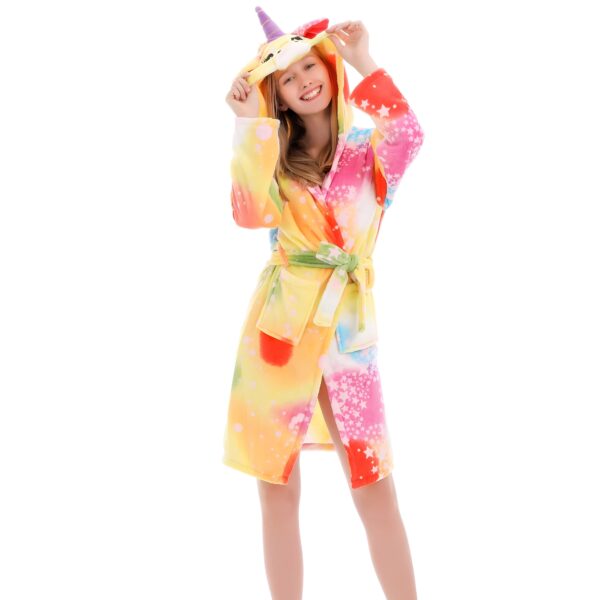 peignoir-licorne-femme-jaune-1a-1.jpg Une jeune femme porte un peignoir licorne. Le peignoir est jaune et rose avec des étoiles et des lunes. La femme a les cheveux longs et blonds et elle sourit.