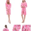 Une jeune femme porte un peignoir rose à capuche avec des motifs de licornes. Le peignoir est doux et moelleux, et il est parfait pour se détendre à la maison. La capuche est doublée de polaire, ce qui la rend encore plus chaude et confortable. Le peignoir est également doté de deux poches, ce qui est pratique pour ranger de petits objets.