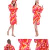 peignoir-licorne-femme-rouge-2a.jpg Une jeune femme porte une robe de chambre rose à capuche en forme de licorne. La robe de chambre est ouverte, on peut voir qu'elle porte un short et un t-shirt. Elle est pieds nus. La robe de chambre est en tissu peluche, elle est douce et chaude. La capuche est doublée de polaire. La robe de chambre est lavable en machine.