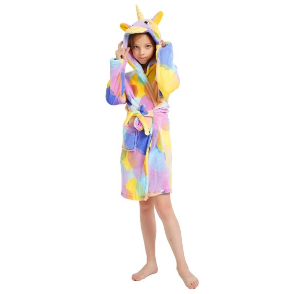 peignoir-licorne-fille-fashion-a-capuche-1a.jpg Une jeune fille porte une robe de chambre licorne. La robe de chambre est rose, violette et jaune avec des pois blancs. La fille a les cheveux blonds et les yeux bleus. Elle est souriante et joyeuse.