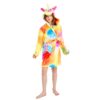 Une jeune fille porte une robe de chambre licorne arc-en-ciel avec une capuche. La robe de chambre est en peluche et a des étoiles multicolores. La capuche a une corne de licorne et des oreilles de licorne. La jeune fille est pieds nus et a les cheveux longs et blonds.