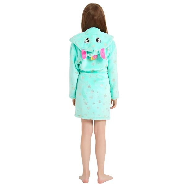 peignoir-licorne-fille-vert-en-coton-5a.jpg Une jeune fille porte une robe de chambre verte à capuche en forme d'éléphant. La robe de chambre est ouverte dans le dos et l'éléphant a une trompe rose et des oreilles grises. La robe de chambre est également décorée d'étoiles dorées.