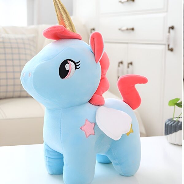 peluche-licorne-bleue-enfant-1a.jpg Une peluche licorne bleue avec une crinière et une queue roses, une corne dorée et des ailes blanches avec des étoiles roses.
