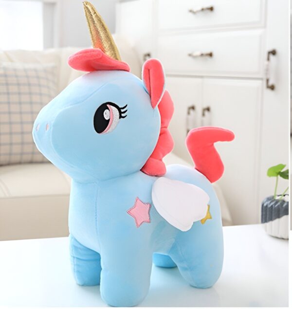 peluche-licorne-bleue-enfant-1a.jpg Une peluche licorne bleue avec une crinière et une queue roses, une corne dorée et des ailes blanches avec des étoiles roses.