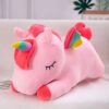 peluche-licorne-couchee-rose-1a.jpg Une peluche licorne rose avec une crinière et une queue arc-en-ciel. La peluche est allongée sur le côté et a les yeux fermés.