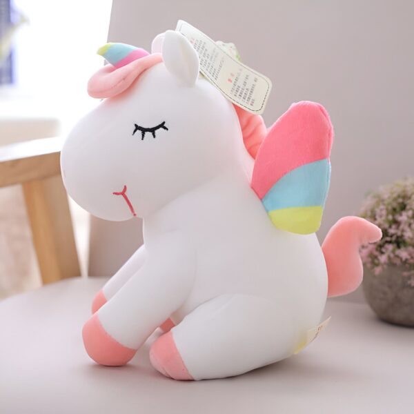 Peluche licorne blanche assise avec des ailes et une corne arc-en-ciel. Jouet doux pour enfants, décoration de chambre, cadeau d'anniversaire. Yeux brodés, détails roses et bleus., 45501420503295 | Licorne Shop