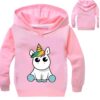 pull-licorne-capuche-fille-1a.jpg Une image d'un sweat à capuche rose pour enfant avec une licorne imprimée sur le devant. La licorne est blanche avec une crinière et une queue arc-en-ciel. Elle est assise sur ses pattes arrière et a les yeux bleus. Le sweat à capuche a une capuche doublée de polaire et des poignets et un ourlet côtelés.