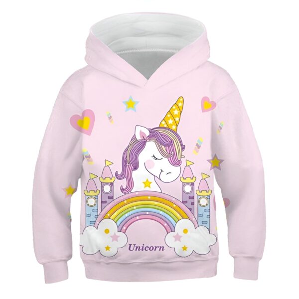 pull-licorne-unicorn-1a.jpg Une illustration d'une licorne debout devant un château. La licorne est blanche avec une crinière et une queue roses. Le château est rose avec des toits bleus et des fenêtres jaunes. Il y a un arc-en-ciel au-dessus du château et des étoiles et des cœurs entourent la licorne.