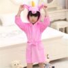 Enfant portant un peignoir rose à capuche en forme de licorne, debout devant un lit et une commode blanche. Deux jouets en peluche, un ours et une poupée, se trouvent à ses pieds., 45502348034303,45502348067071,45502348099839,45502348132607,45502348165375,45502348198143,45502348230911,45502348263679 | Licorne Shop
