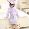 robe-licorne-douce-pour-enfant-walm-1a.jpg Une petite fille porte un peignoir licorne coloré avec des étoiles, debout près d'un lit avec des jouets., 45502344986879,45502345019647,45502345052415,45502345085183,45502345117951,45502345150719,45502345183487,45502345216255 | Licorne Shop