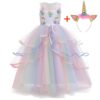 Une robe de licorne blanche et rose avec des fleurs et des paillettes. La robe est composée de plusieurs couches de tulle et est très volumineuse. Elle est accompagnée d'un serre-tête avec une corne de licorne.