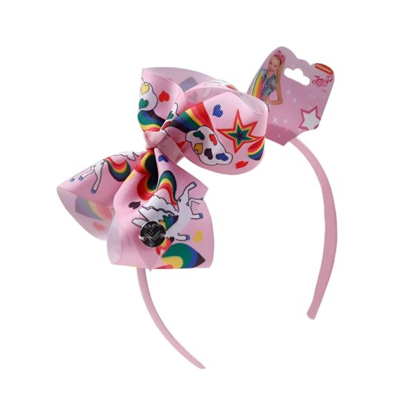 serre-tete-licorne-rose-a-corne-doree-et-paillettes-1a.jpg Serre-tête rose pour enfant avec un grand nœud JoJo Siwa. Le nœud est rose et décoré de motifs licornes, arcs-en-ciel, étoiles et cœurs. L'emballage est visible en haut à droite., 45501376168191 | Licorne Shop