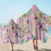 Personnes sur la plage portant des serviettes de bain à capuche avec imprimé de licornes et de fleurs roses. Serviettes poncho décoratives pour enfant., 45501253320959 | Licorne Shop