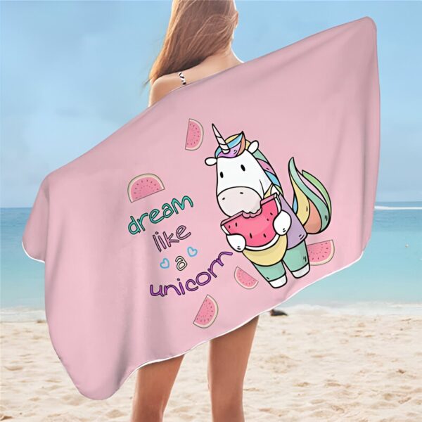 Femme à la plage tenant une serviette rose avec une licorne mangeant une pastèque. L'inscription "dream like a unicorn" est également visible., 45501255418111 | Licorne Shop