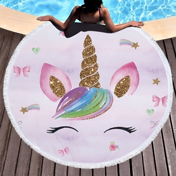 serviette-de-plage-ronde-epaisse-motif-licorne-1a.jpg Serviette de plage ronde avec motif licorne rose et doré. Une femme se prélasse au bord de la piscine, la serviette étalée sur le sol en bois. Détails brillants et motifs enfantins., 45501256532223 | Licorne Shop