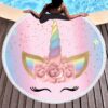 Une personne se détend près d'une piscine sur une serviette de plage ronde avec un motif de licorne colorée, avec un fond rose et bleu, des paillettes dorées et des détails floraux., 45501255090431 | Licorne Shop