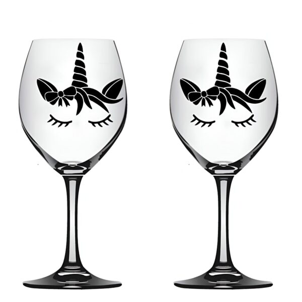 Deux verres à vin transparents décorés d'une silhouette noire de licorne stylisée, avec des cils fermés, un nœud et une corne. Idéal pour une décoration de table féérique ou un cadeau original., 45501134471423 | Licorne Shop
