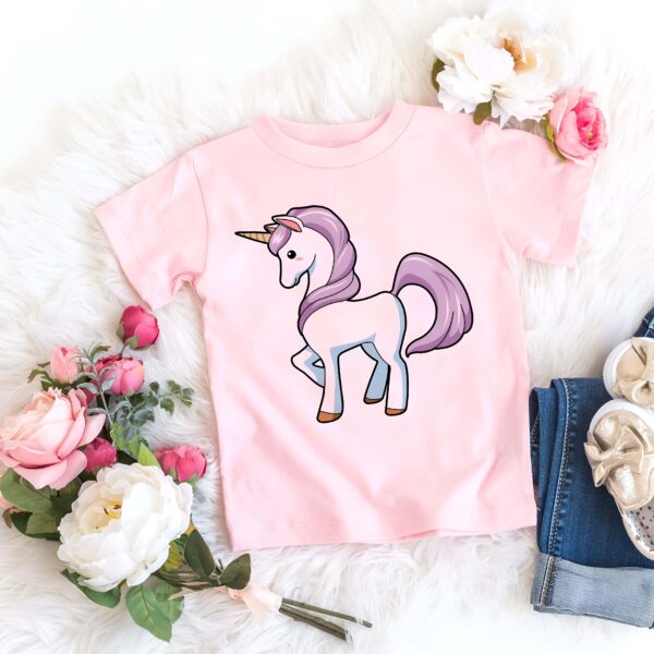 t-shirt-enfant-licorne-mignonne-1a.jpg T-shirt rose clair avec un dessin de licorne, entouré de fleurs roses et blanches, d'un jean bleu et de chaussures dorées, le tout sur une couverture blanche duveteuse., 45502324965631,45502324998399,45502325031167,45502325063935,45502325096703,45502325129471,45502325162239,45502325195007 | Licorne Shop