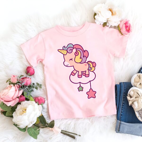 t-shirt-imprime-licorne-mignonne-1a.jpg T-shirt rose enfant avec illustration d'une licorne sur un nuage. Fleurs et chaussures enfantines en arrière-plan. Vêtement doux et mignon pour les tout-petits., 45502326898943,45502326931711,45502326964479,45502326997247,45502327030015,45502327062783,45502327095551,45502327128319 | Licorne Shop