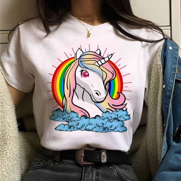 t-shirt-licorne-animal-unicorne-1a.jpg Une illustration d'une licorne blanche avec une crinière et une queue arc-en-ciel. La licorne est debout sur un nuage et il y a un arc-en-ciel derrière elle.