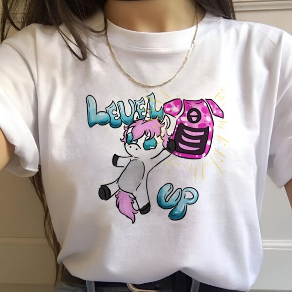 Une illustration d'une licorne blanche et grise avec une crinière et une queue roses et bleues. La licorne porte un sac à dos rose avec un écusson représentant un téléphone portable. Le texte "Level Up" est écrit en bleu et rose au-dessus de la licorne.